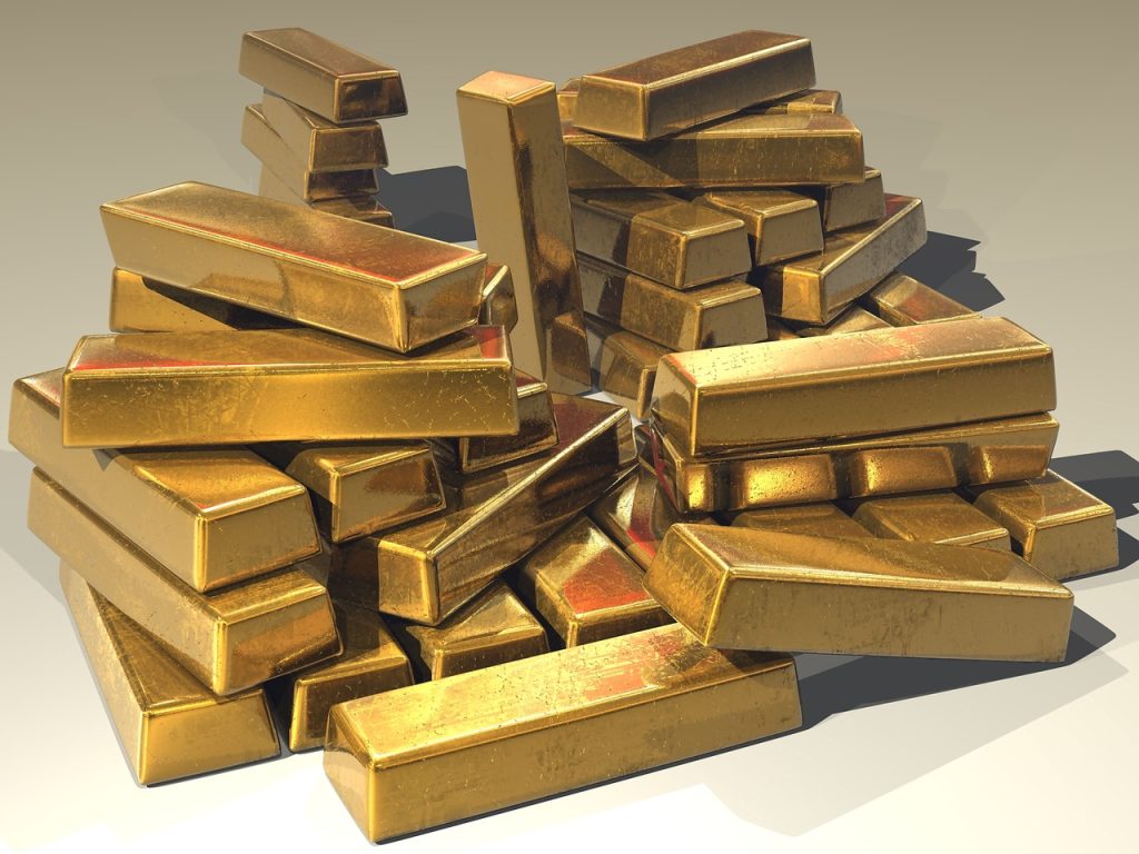 A pile of loosely-stacked gold bars on a neutral background.