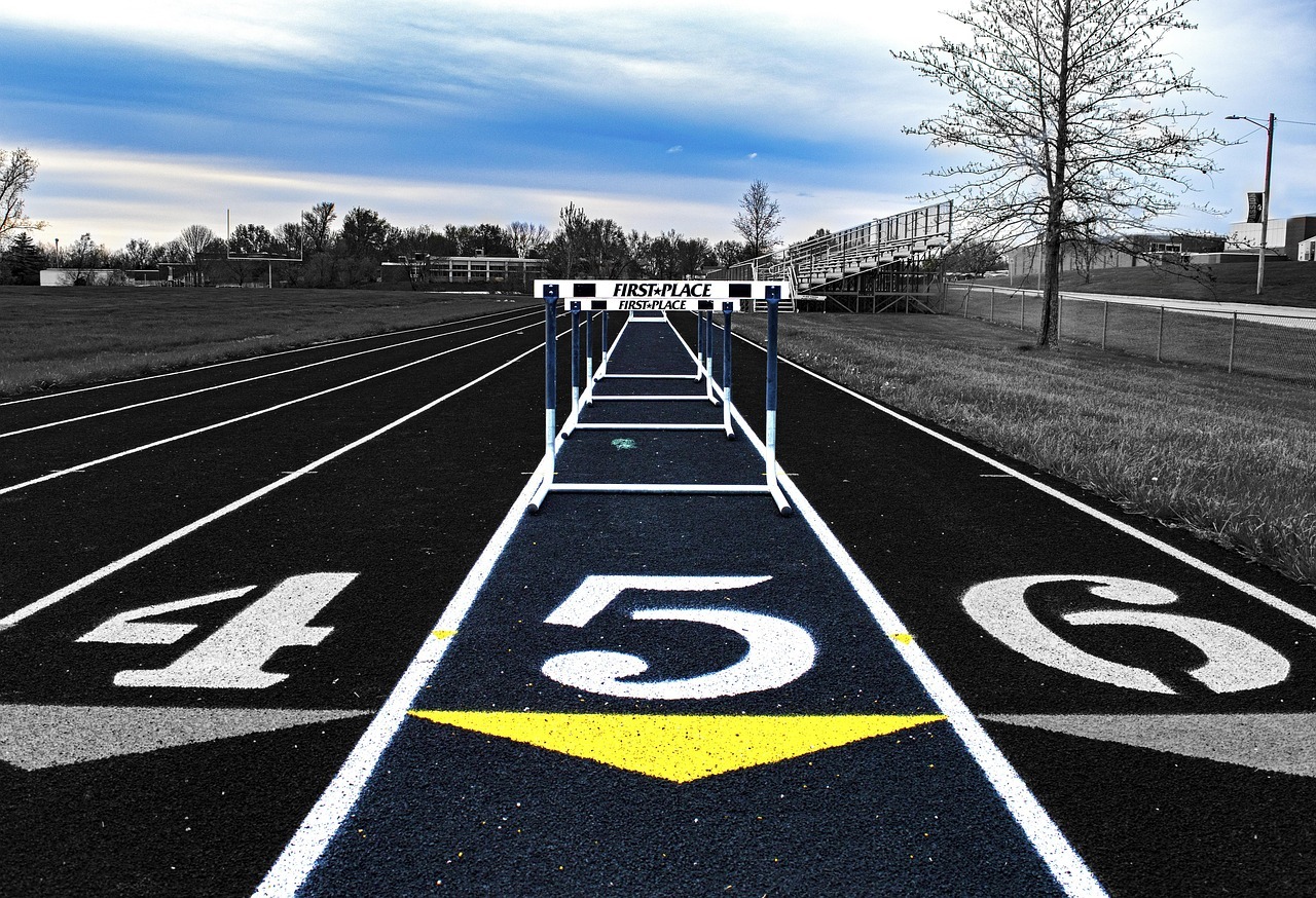An empty track with a lane of hurdles facing the viewer