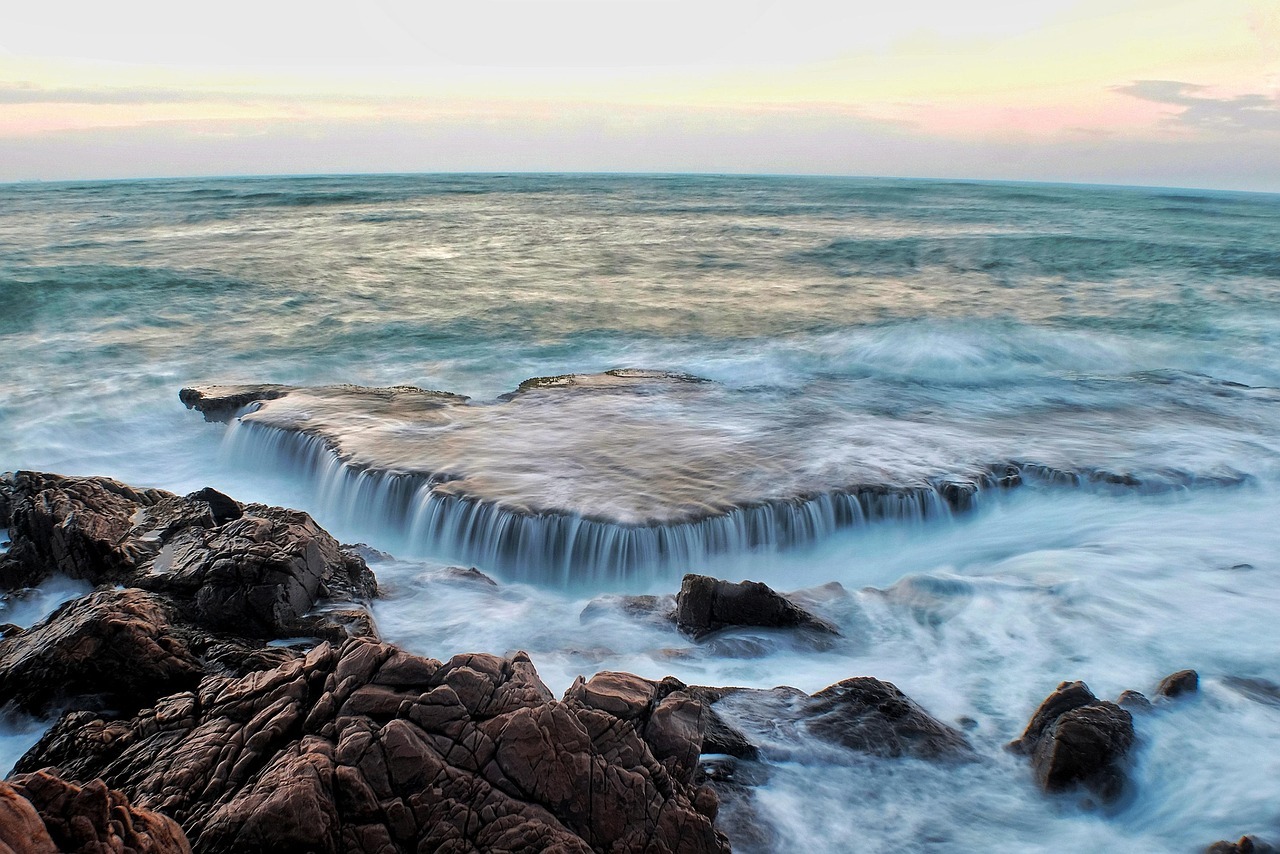The ocean flowing over rocks at the shore.